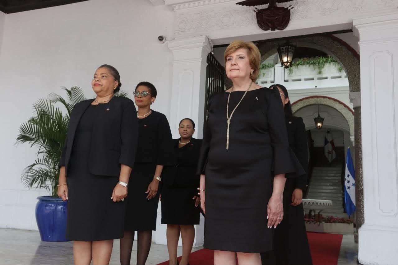 L'ambassadrice Raymonde Fabienne Carré Sajous et des membres de sa délégation, en tenue noire, posent à l'extérieur du Palais présidentiel après la cérémonie.